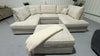 Beige sectional sofa with ottoman in a room setting