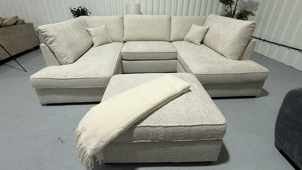 Beige sectional sofa with ottoman in a room setting
